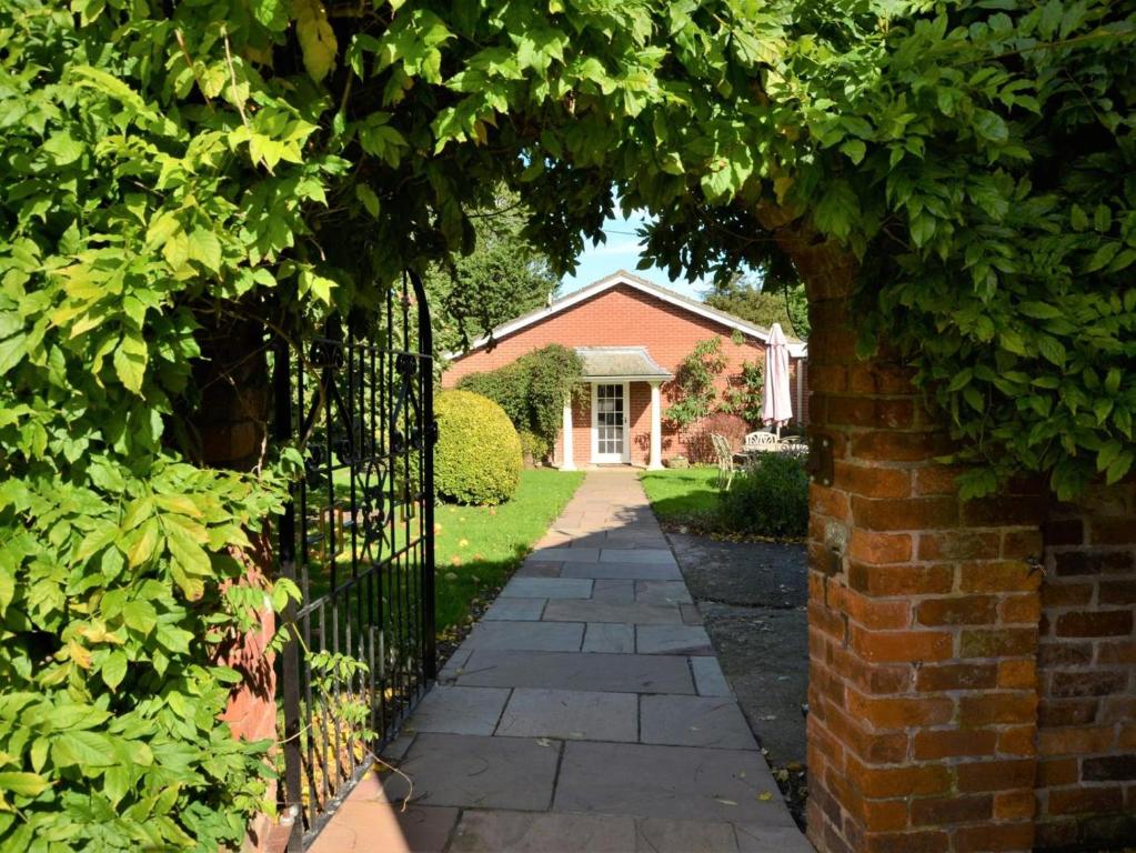 a gate to a brick house with a driveway at 3 Bed in Wrexham oc-39974 in Overton