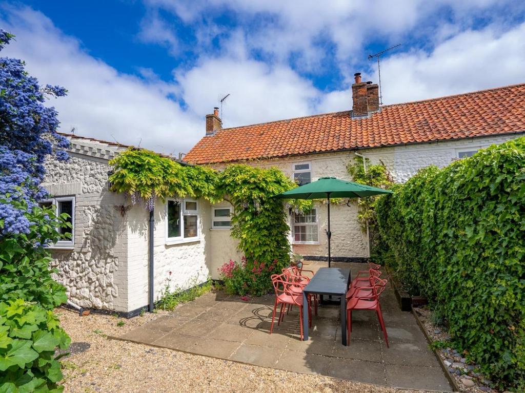 a patio with a table and chairs and an umbrella at 3 Bed in Kings Lynn oc-43950 in Docking