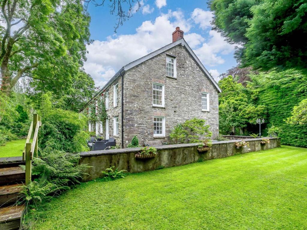 an old stone house with a stone wall in the yard at 2 Bed in Llandysul oc-85444 in Felindre