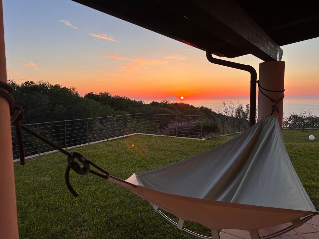 a hammock on a porch with the sunset in the background at GREEN APARTMENT in VILLA ANGISI in Drapia