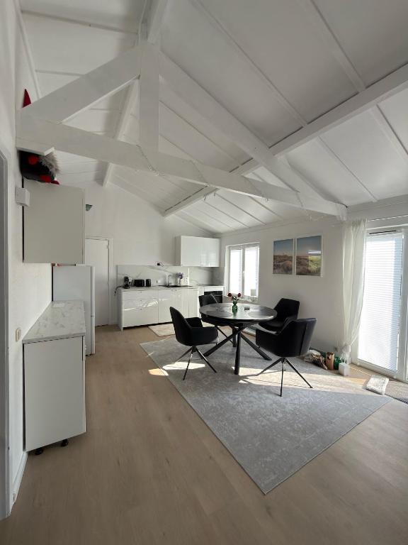 a living room with a table and chairs and a kitchen at Dune Nest 233 - beautiful house near beach - up to 4 guests with garden, parking, WLAN in Bredene