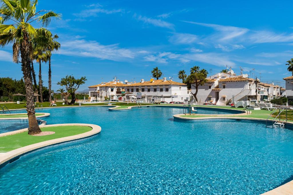 a swimming pool in a resort with palm trees and buildings at Lago Jardin 69 in Los Altos
