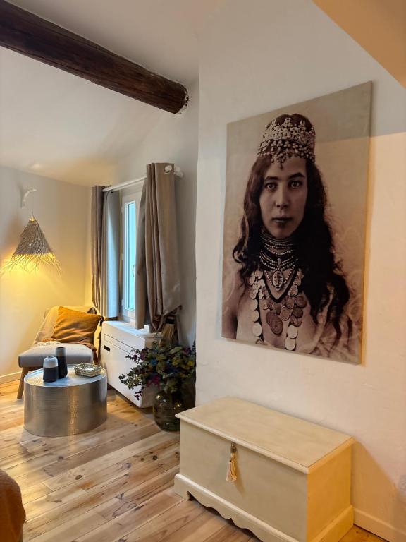 a room with a portrait of a woman on the wall at Mon nid sous les toits in L'Isle-sur-la-Sorgue