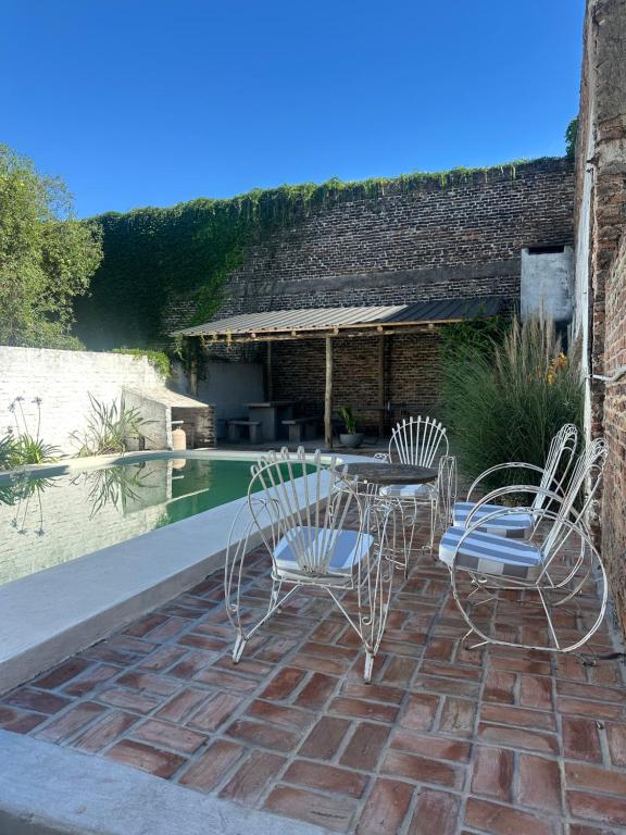 a patio with a table and chairs next to a pool at BichoNegro Hostel in Concordia