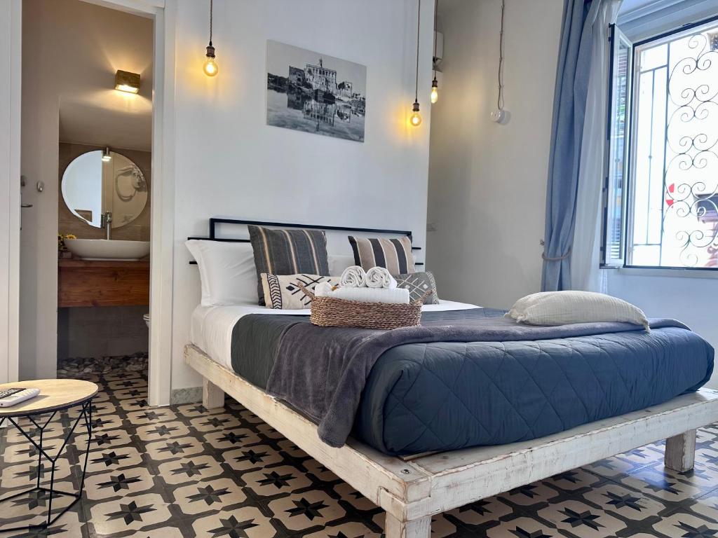 a bedroom with a large bed with a blue pillow at Nap25guesthouse in Polignano a Mare