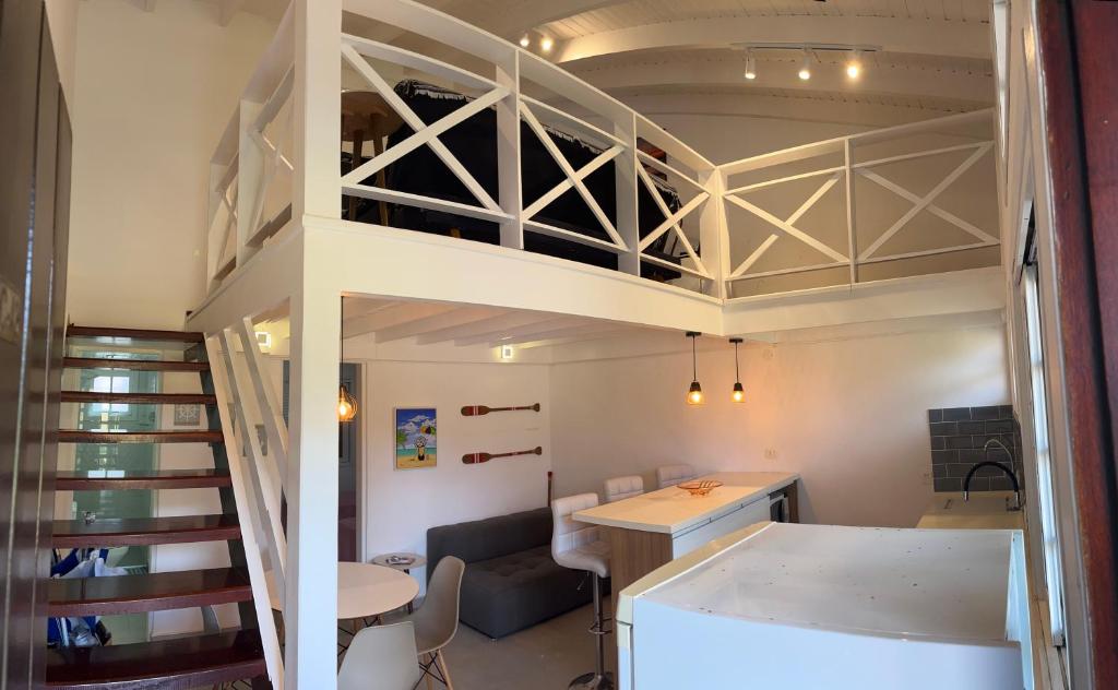a room with a loft bed with a desk and a table at Flat Duplex Premium - Maresias - 150m da Praia Piscina, Wi-Fi e Garagem in São Sebastião