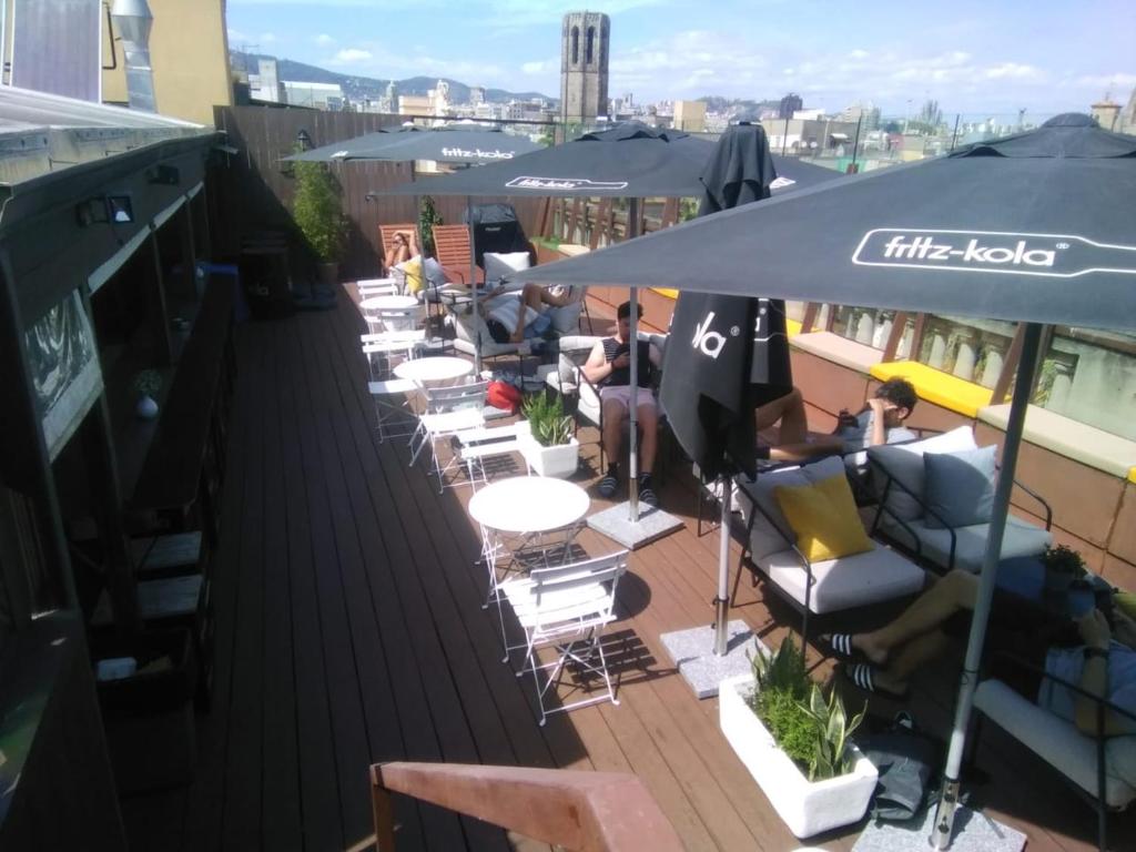 a row of chairs and tables on a rooftop patio at Kabul Party Hostel Barcelona in Barcelona