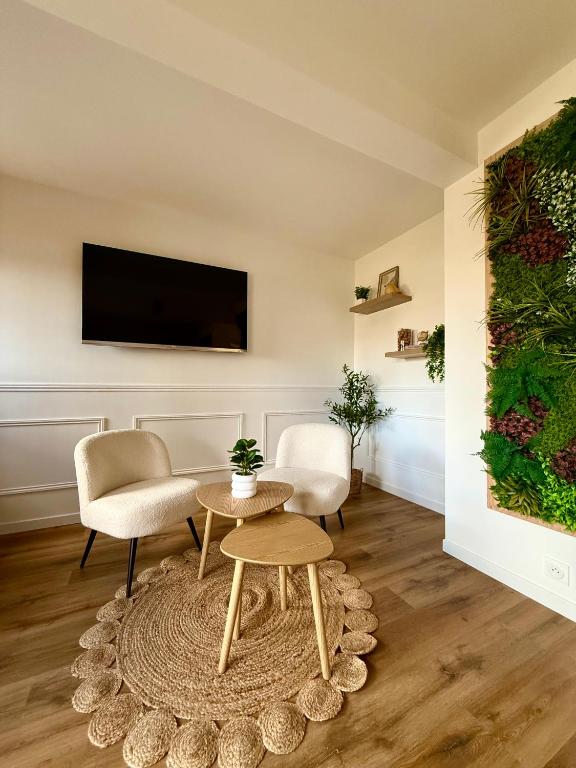a living room with a tv and a table and chairs at FLOK horizon in Malbuisson