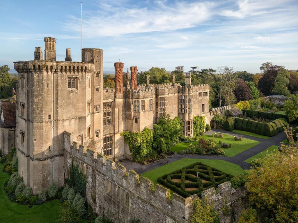 an old castle with a garden in front of it at Thornbury Castle - A Relais & Chateaux Hotel in Thornbury