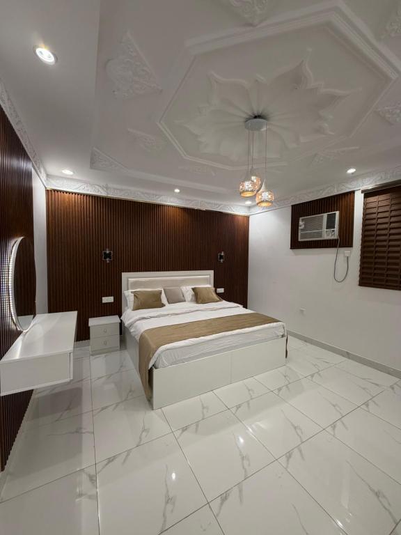 a bedroom with a large bed and a table at شقق النبلاء in Medina