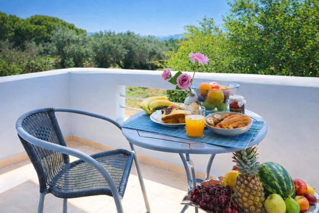 a blue table with a tray of fruit on a balcony at Diana's Houses in Gythio