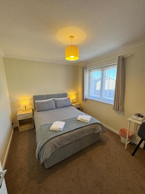 a bedroom with a bed with two towels on it at Comfortable double room with own bathroom in Inshes