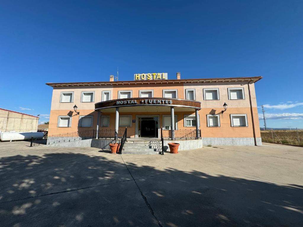 a brick building with a sign on top of it at Hostal Fuentes in Labajos