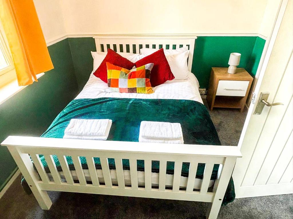 a bed with colorful pillows on it in a room at New Hampton Units in Wolverhampton