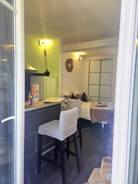 a room with a bed and a table and chairs at STUDIO DE L'HORLOGE in Dinan