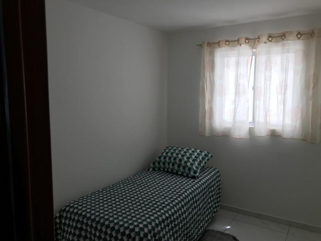 a bed sitting in a room with a window at CONDOMÍNIO BOSQUE IMPERIAL ll in João Pessoa