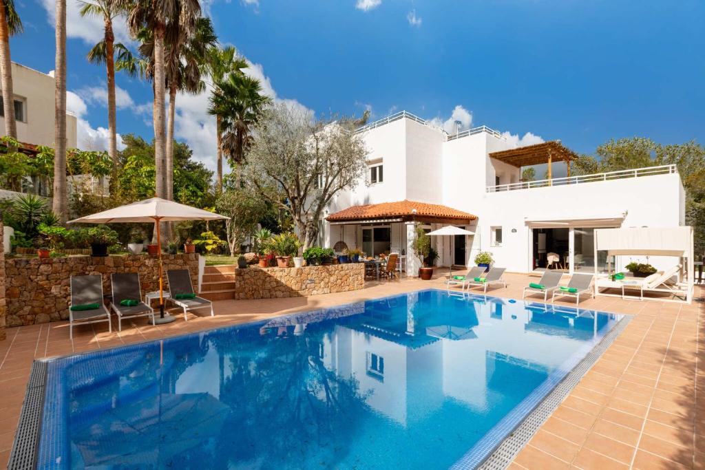 a swimming pool in front of a house at Villa Blanca Santa Eulalia in Santa Eularia des Riu