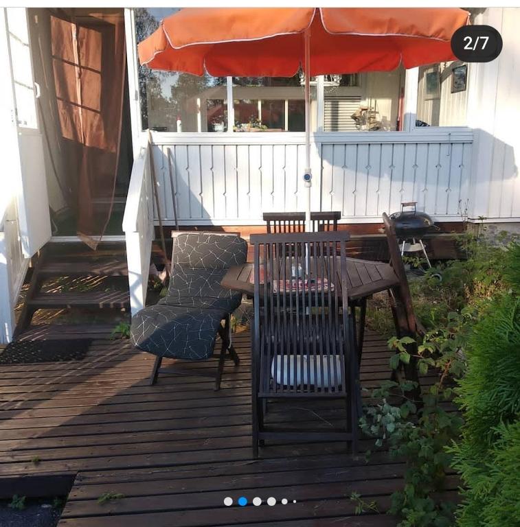 a patio with a table and chairs and an umbrella at Дом на берегу озера Саймаа in Ruokolahti