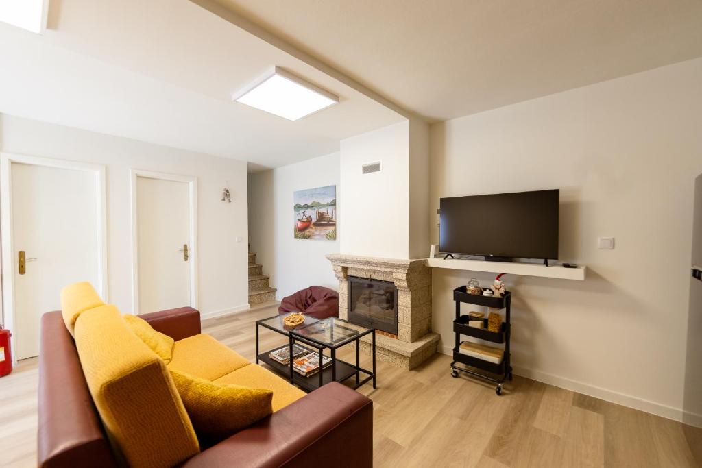 a living room with a couch and a fireplace at Casa Estação Douro Vista in Vila Marim