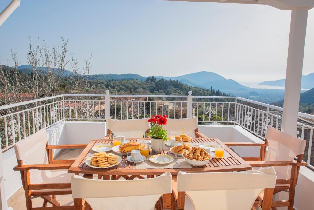 a table with breakfast food on the balcony of a house at Casa Dimilia in Sívros