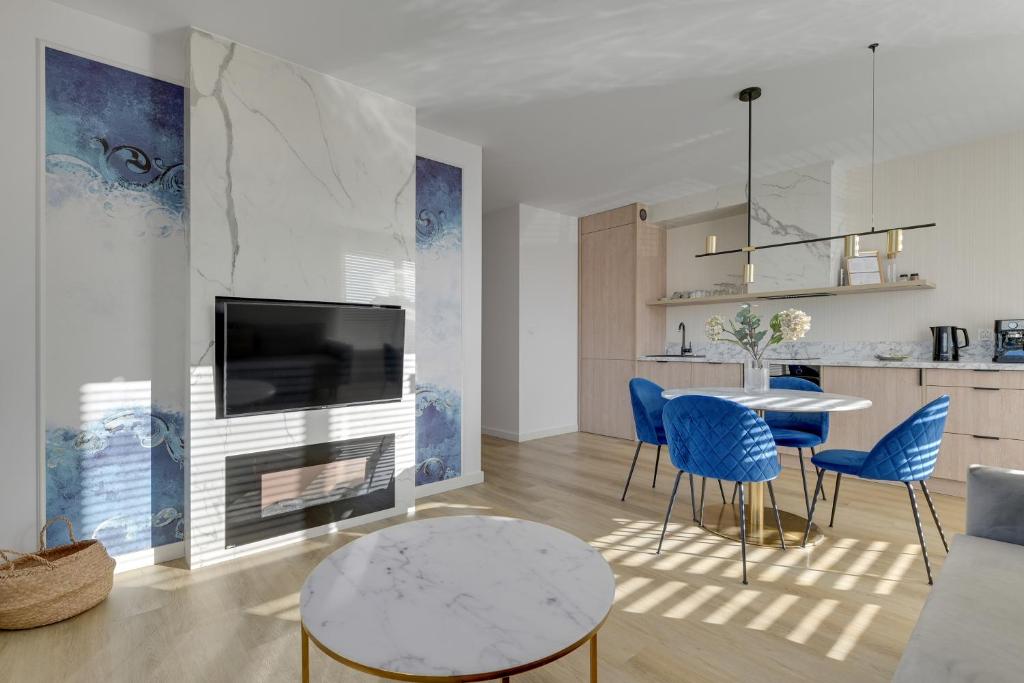 a living room with a table and blue chairs at GRANO FLATS Sobieszewo - Villa Neptun in Sobieszewo