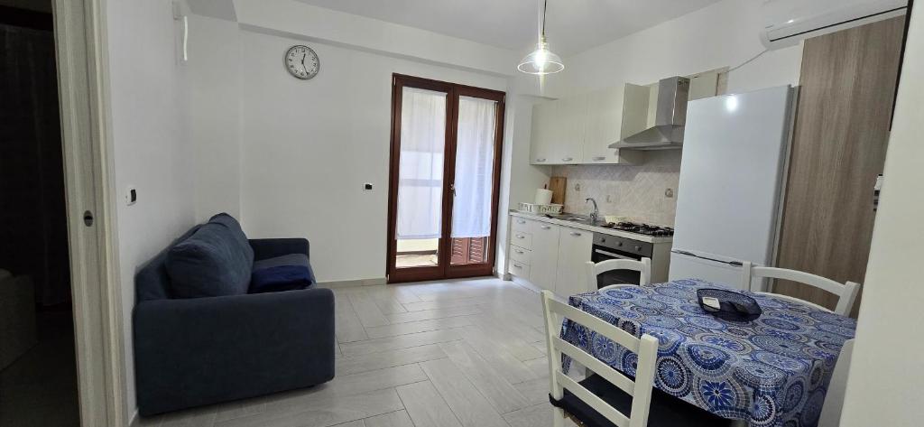 a kitchen with a table and a couch and a table and a chair at La Casetta Nuova struttura in Palinuro