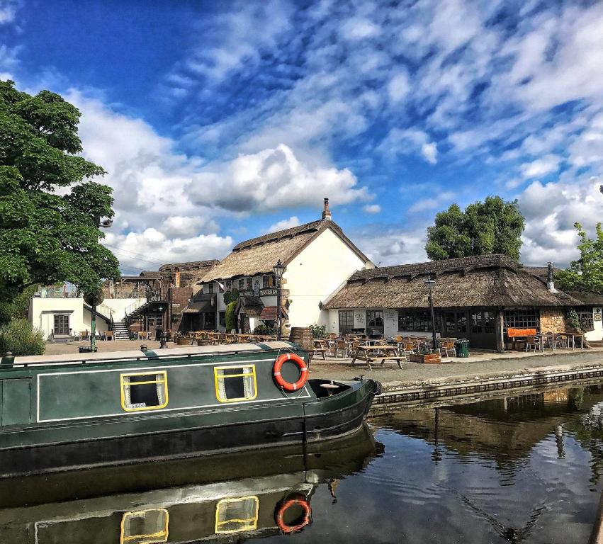 a boat sitting in the water next to a building at Owd Nell's Tavern in Garstang