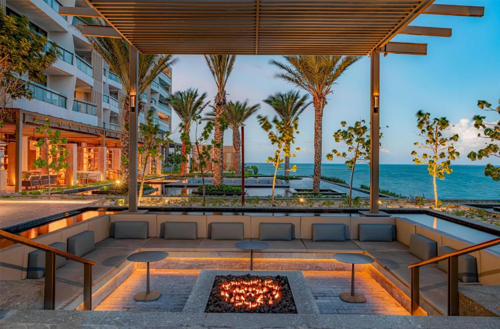 an outdoor patio with a fire pit and the ocean at Waldorf Astoria Riviera Maya in Cancún