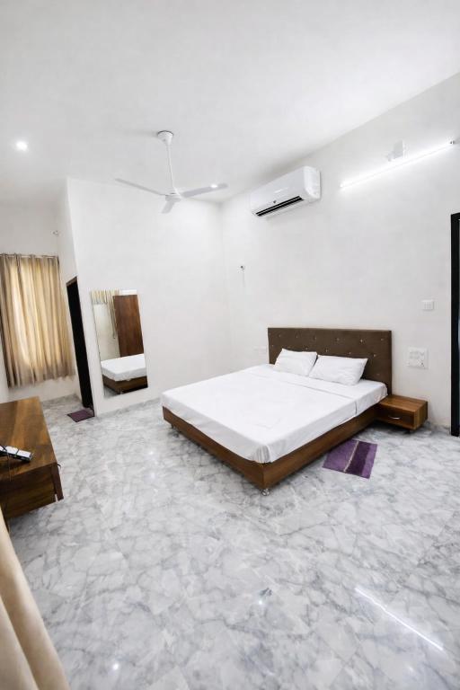 a bedroom with a bed in a white room at Takery Resort in Chittaurgarh