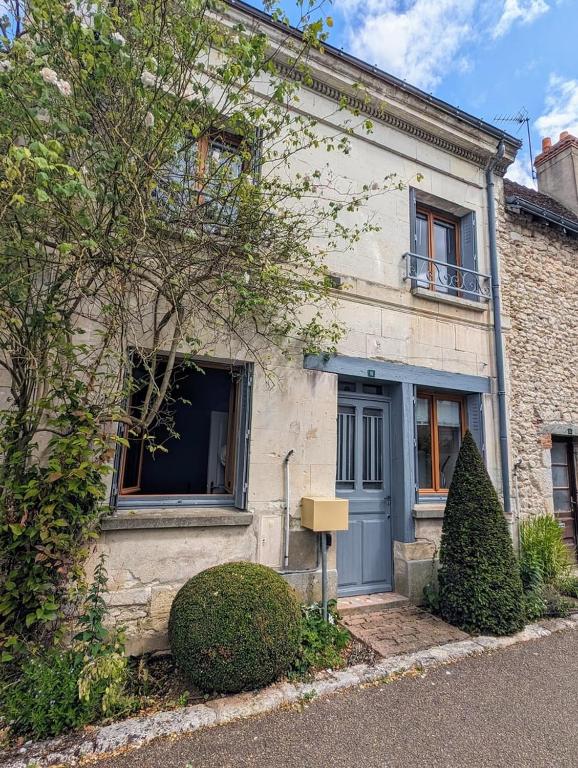 a white brick house with a blue door at La rose d'Alfred in Chédigny
