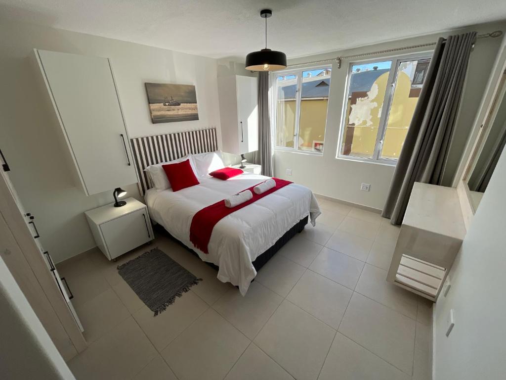 a bedroom with a large bed with red pillows at Central Apartment at Bismarck5 in Swakopmund