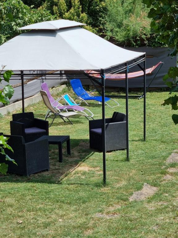 a white umbrella and chairs under a tent at Ombre d'été in Ruoms