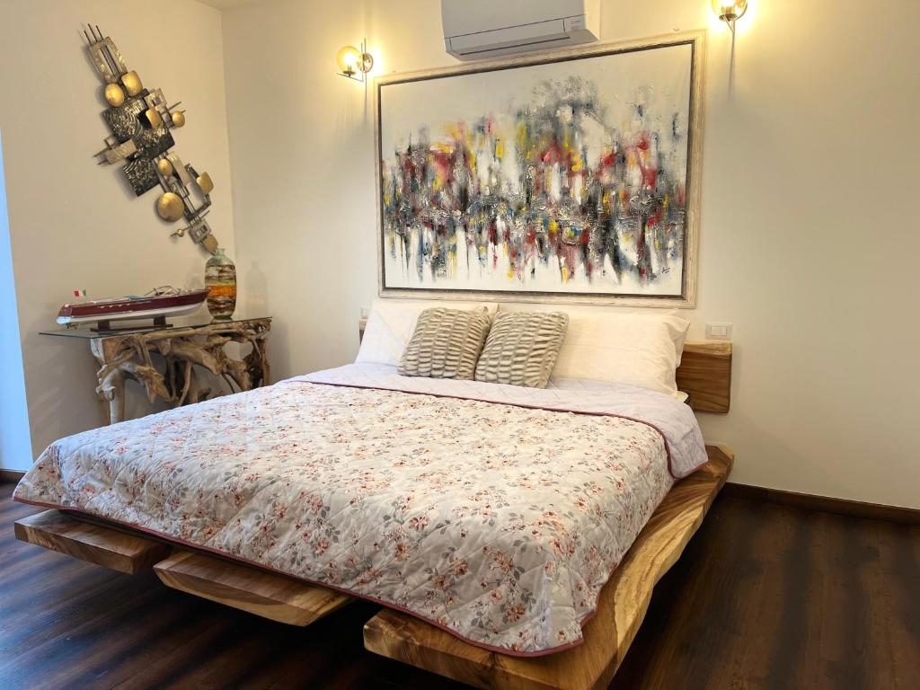 a bedroom with a bed with a painting on the wall at Menaggio Lake Como Elegance in Menaggio