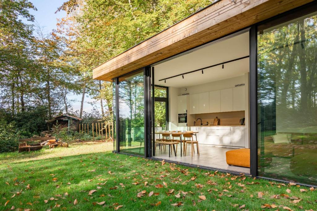 a glass extension of a house with a backyard at Glass Forest Cabin Holenduif I Privacy I 3BR Quiet in Oostkamp