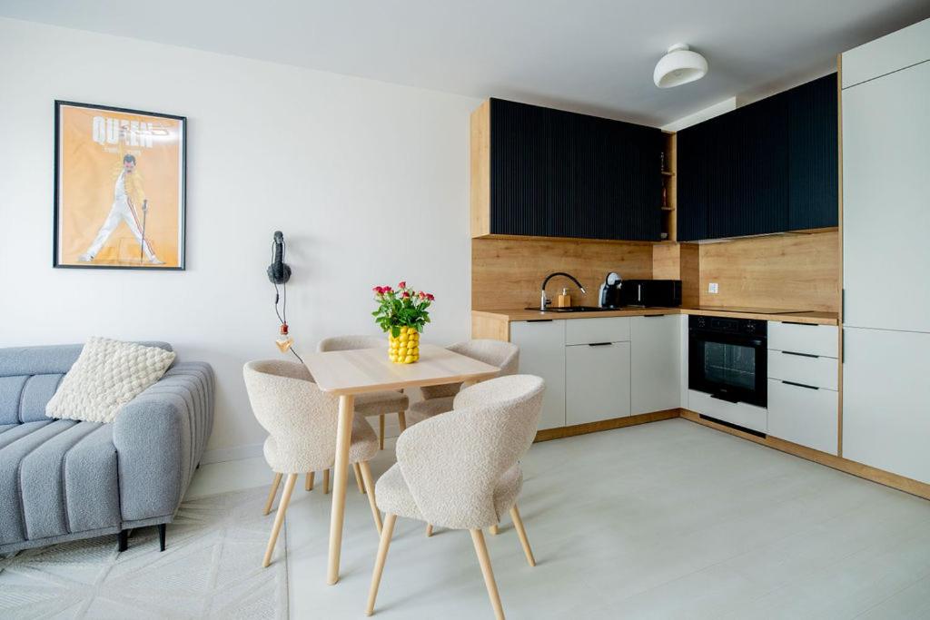 a kitchen and living room with a table and a couch at Apartament Staymonte in Wrocław