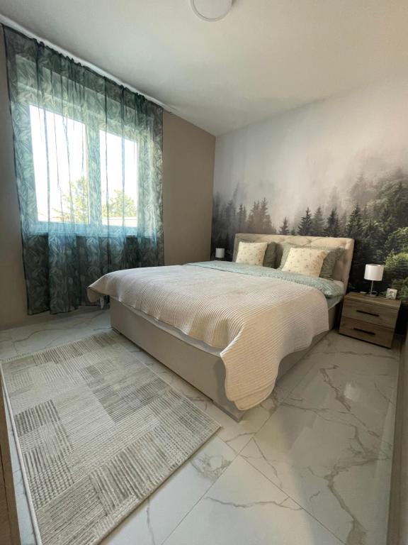 a bedroom with a bed with a painting on the wall at Apartman Green Oaza in Vrbas
