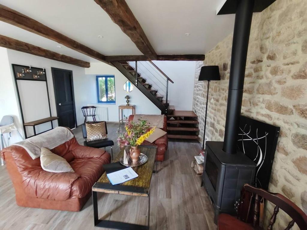 a living room with a couch and a fireplace at Gîte Le Petit Menhir in Trans