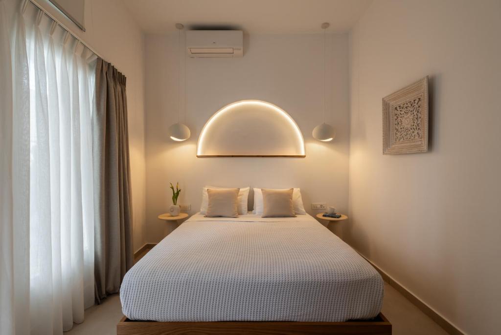 a bedroom with a bed and a window at Galation in Mikonos