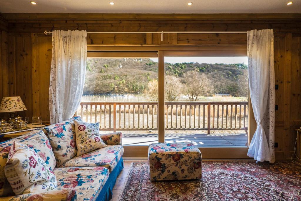 a living room with a couch and a large window at Maso Scricciolo Farm House in Vezzano