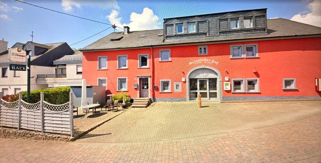 a large red building with a gate in front of it at Gästehaus Back - Reisfelder Hof in Reinsfeld