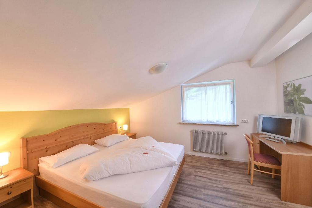 a bedroom with a bed and a desk and a television at Texel Apartments in Madonna