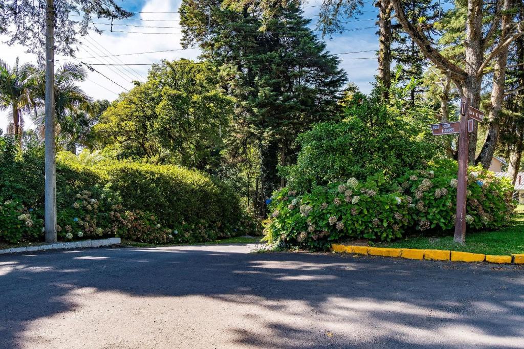 a road with bushes and a street sign on it at Rosa Chalé do Vô Walter in Gramado