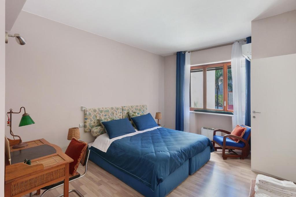 a bedroom with a blue bed and a desk at Casa Frank 2 in Torre Annunziata