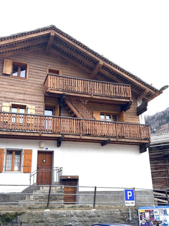a wooden house with a balcony on the side of it at Cosy duplex close to Verbier in Bruson