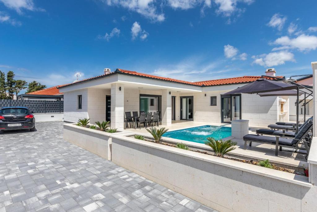 a house with a swimming pool and a patio at Mariva in Vir