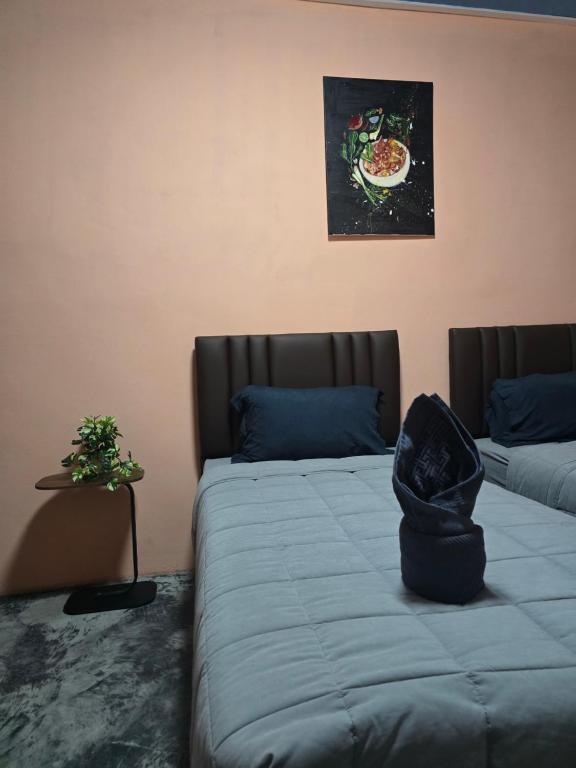 a room with two beds and a picture of a pizza on the wall at โรงแรมเลทุ่งแล่น 109 in Ban Phru Ching (1)