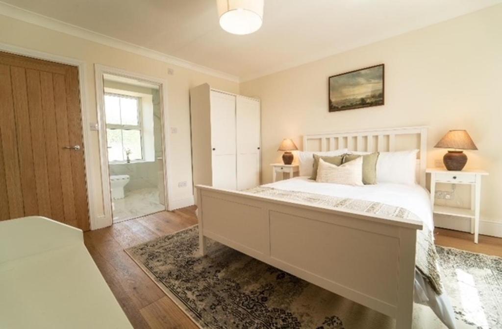 a bedroom with a large bed and a bathroom at Foundry Farm House - 4 bedrooms in Hexham