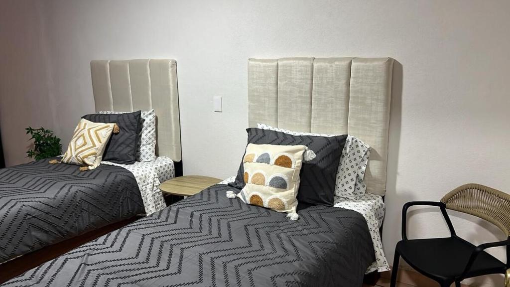 a bedroom with two beds with pillows at Casa Homero 23 in Morelia