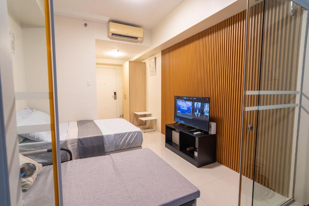 a small room with a bed and a television at BreezeVista Getaway in Kaybagal