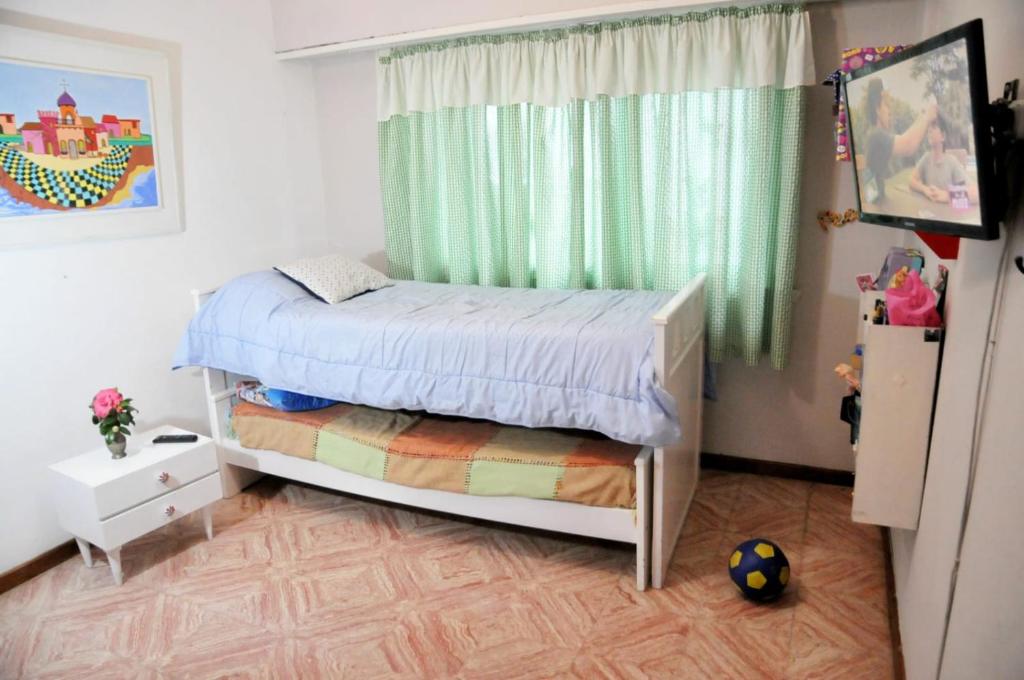 a small bedroom with a bed and a window at Departamento 1ph in Miramar